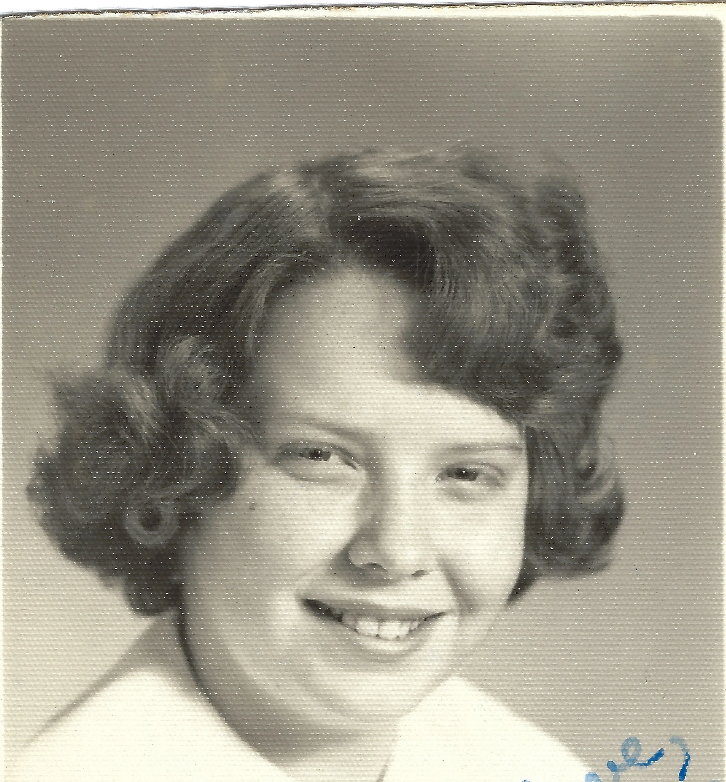 A sepia school portrait of Cacky as a teenager with curled hair, around 1962