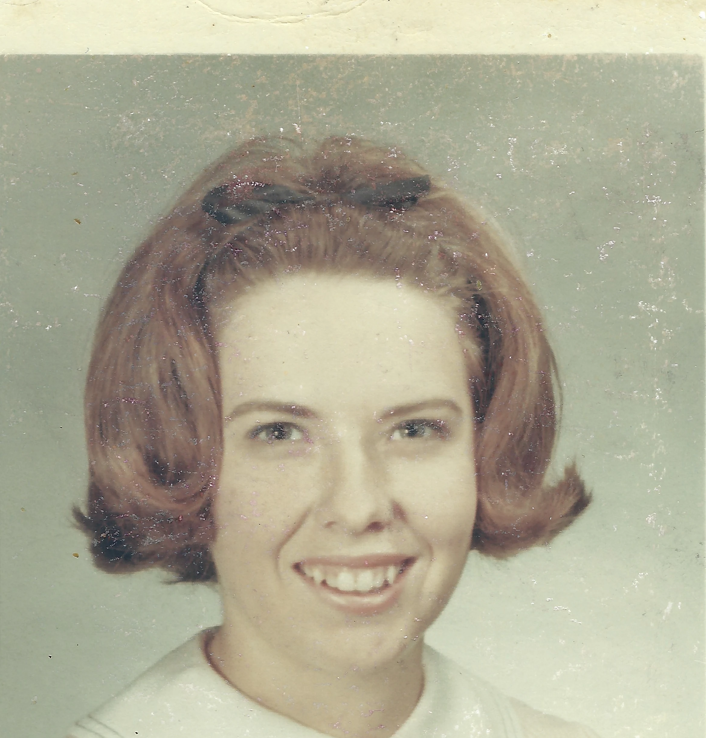 A color studio portrait of Cacky as a young woman with an auburn bouffant and a bow clip, around 1964