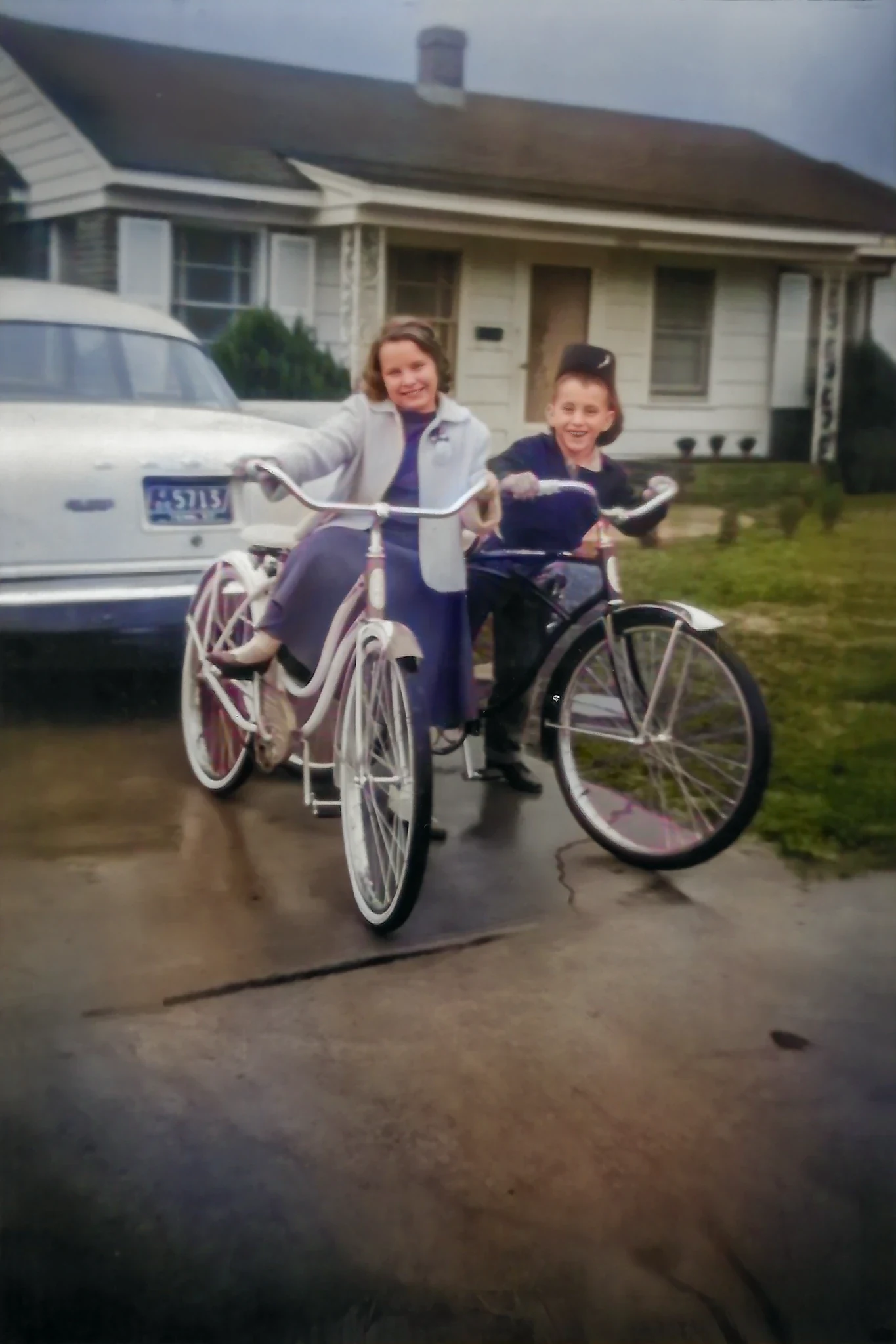 Cacky and David smiling beside their brand new bicycles in 1960