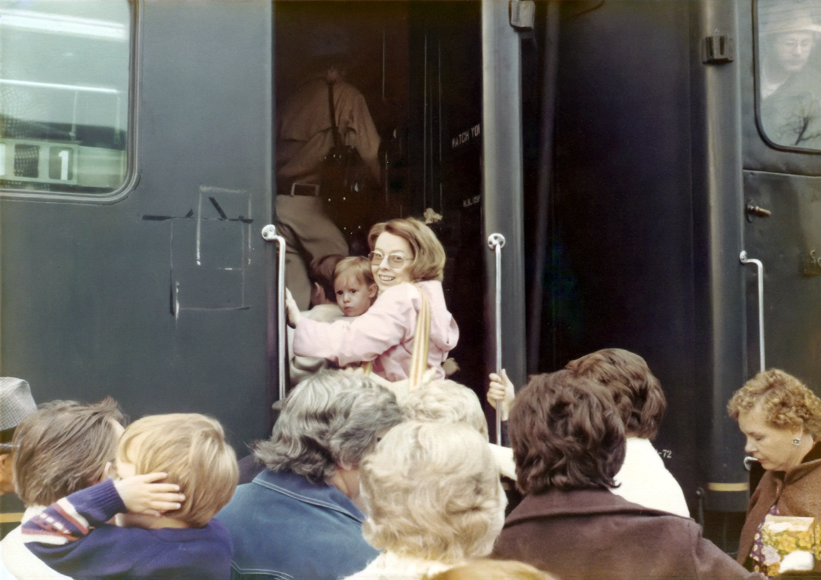 Cacky holds Jennifer while boarding a crowded train in 1978