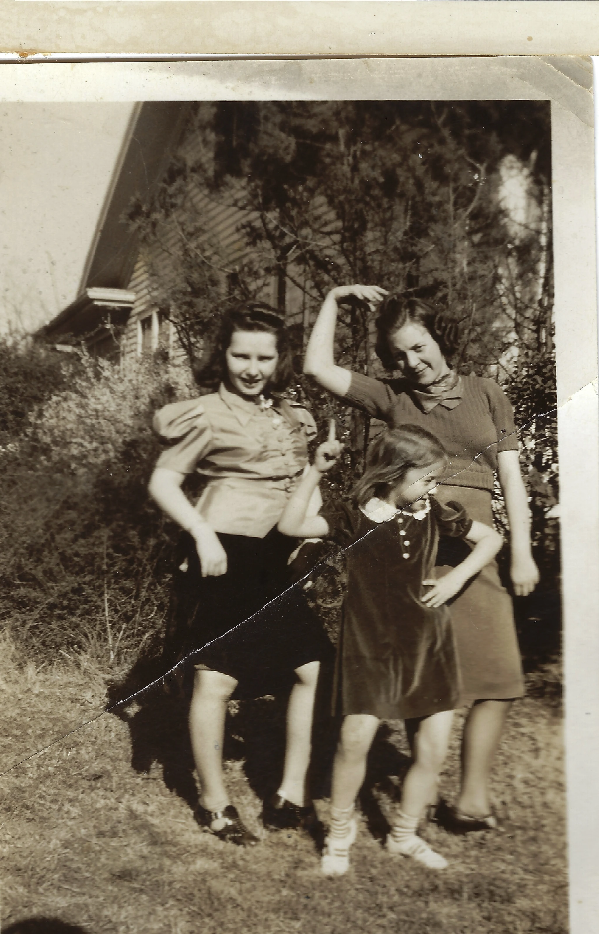 Two teenage girls and a younger girl posing playfully in a yard — family members with Gruzel among them, around 1939