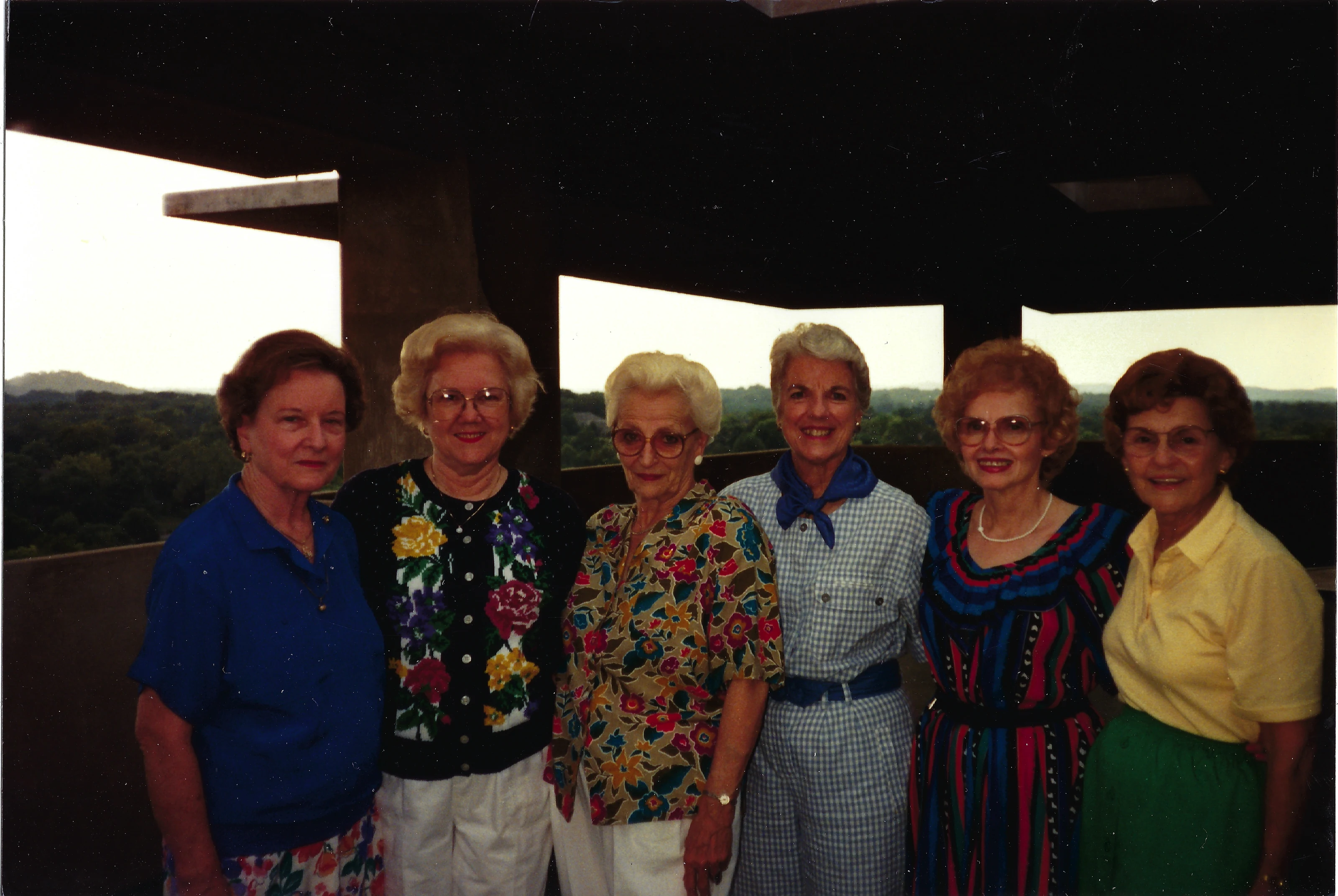 Six older women posing together on an observation deck overlooking hills, Gruzel (b.1924) among them, around 1994