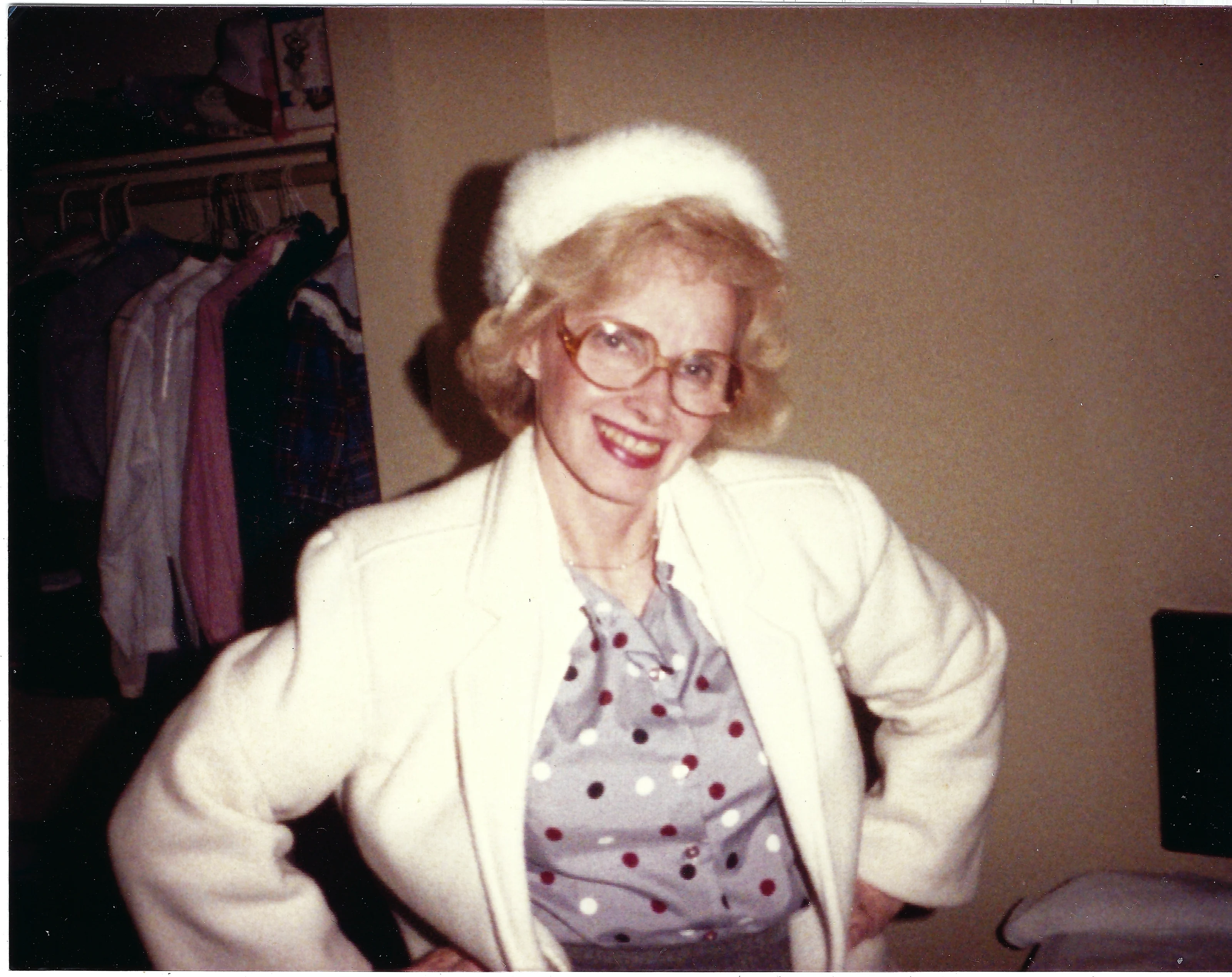 Gruzel (b.1924) in a white fur hat and cream jacket, hands on her hips, around 1993