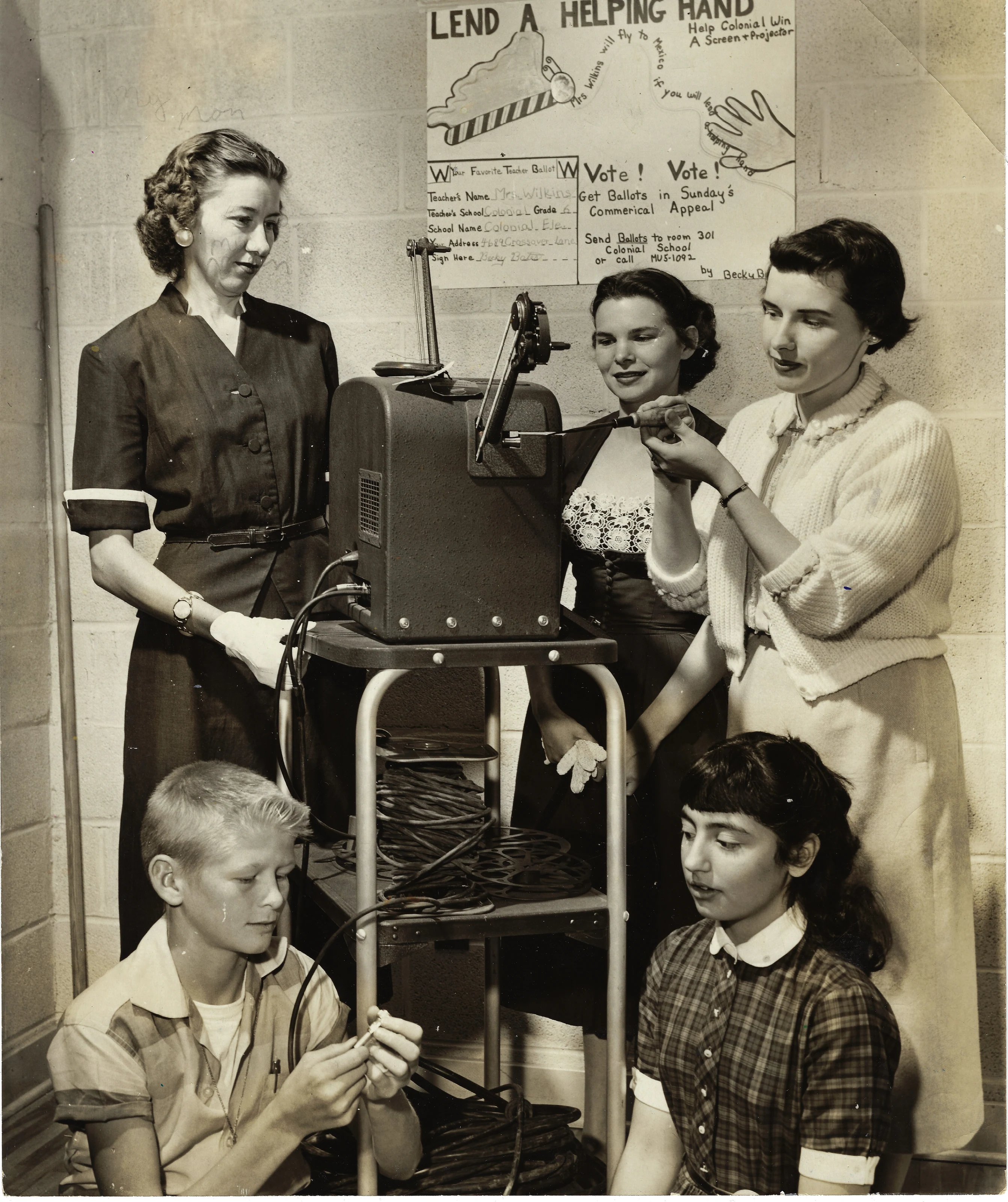 Mrs. Wilkins (Gruzel) and her students with a film projector for the Commercial Appeal 'Lend a Helping Hand' campaign, around 1962