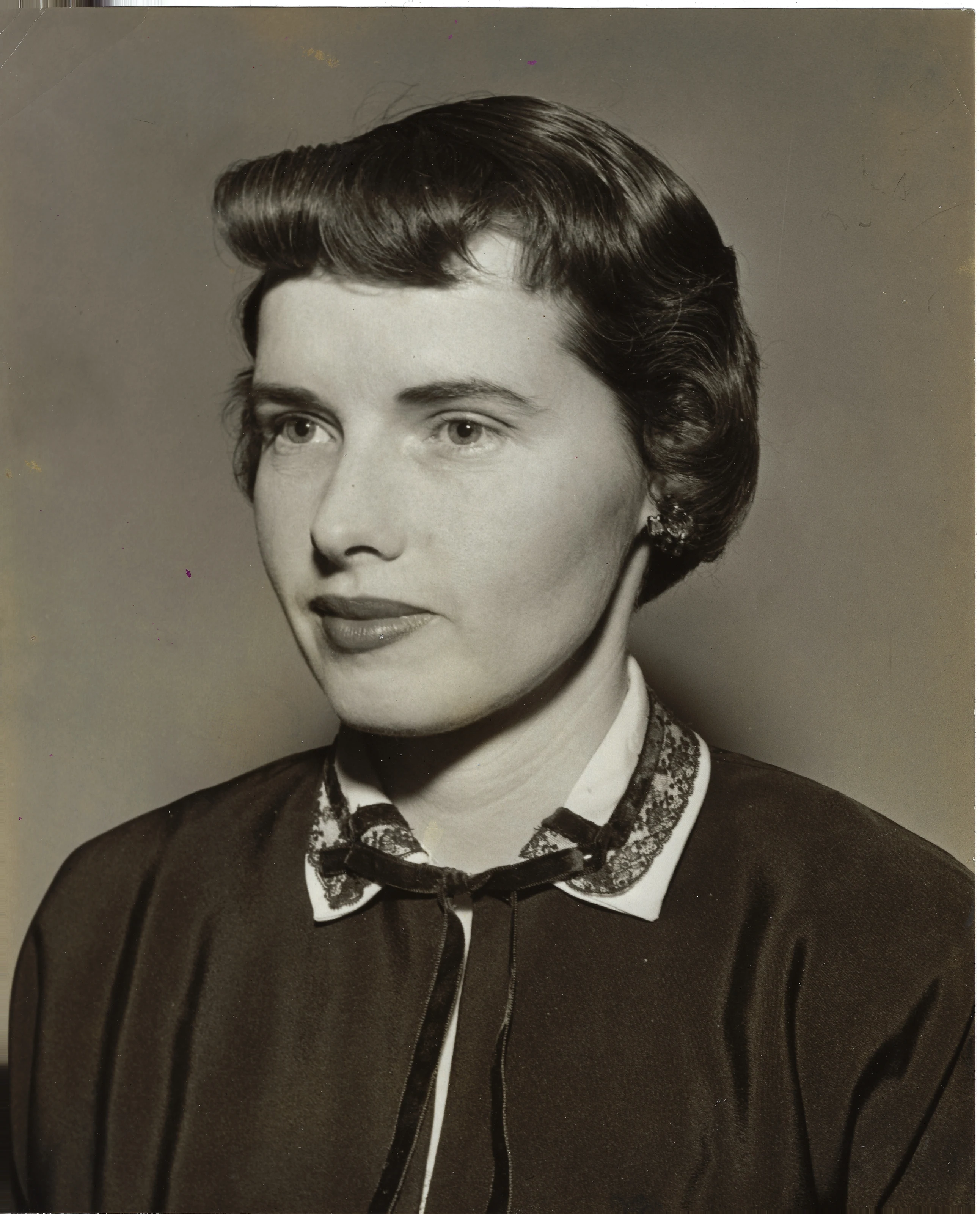 An early-1950s studio portrait of Gruzel (b.1924) with a 1950s wave and a lace-collared cardigan, around 1953