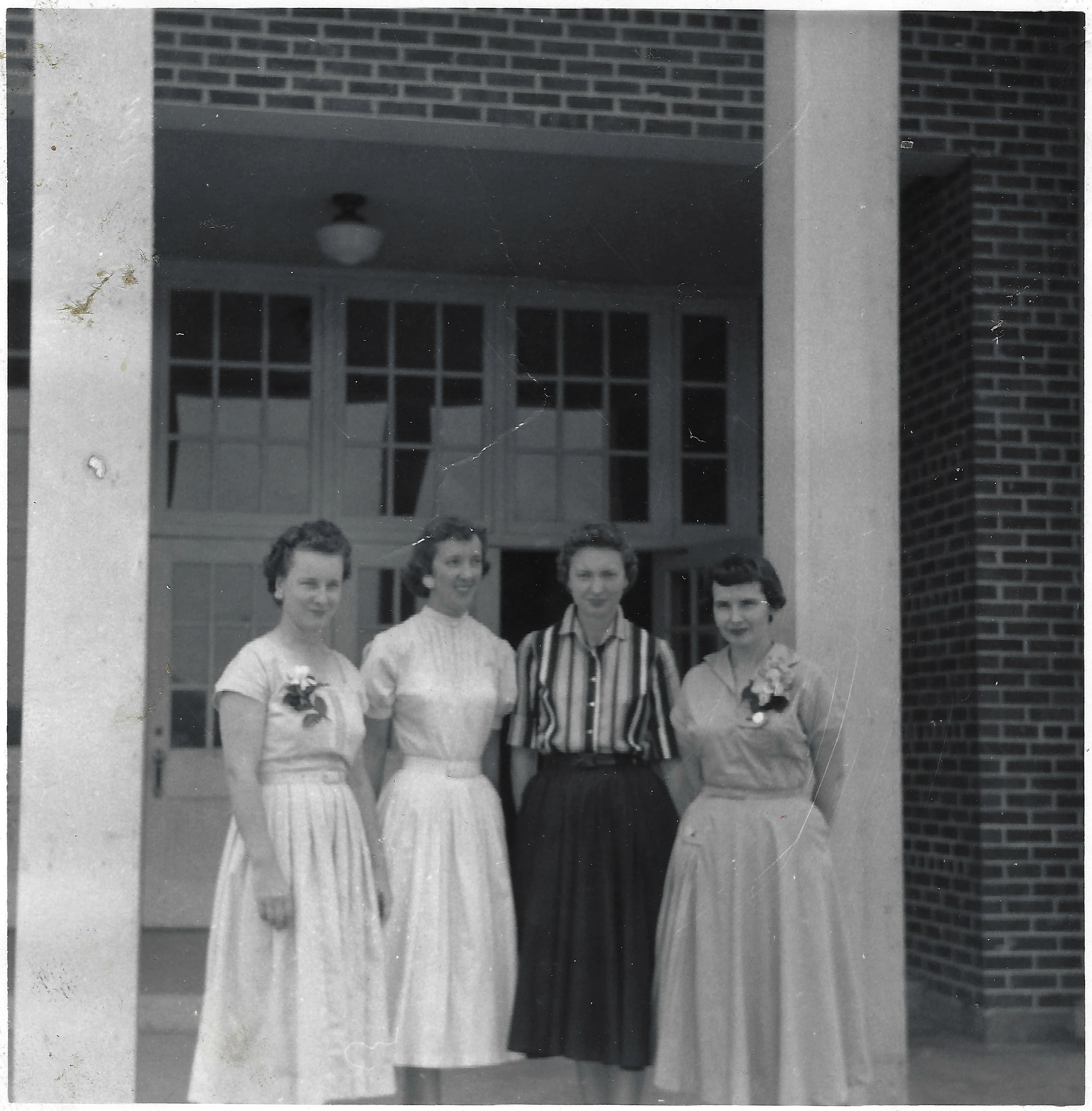 Four women with corsages standing under a brick portico, Gruzel (b.1924) among them, around 1962