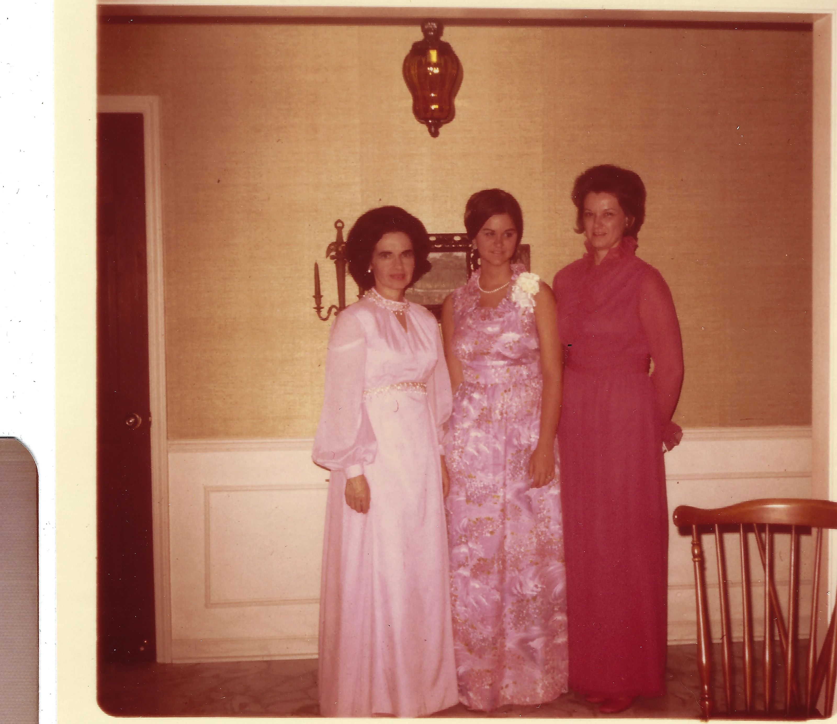 Three women in floor-length formal gowns posing indoors, Gruzel (b.1924) among them, around 1972