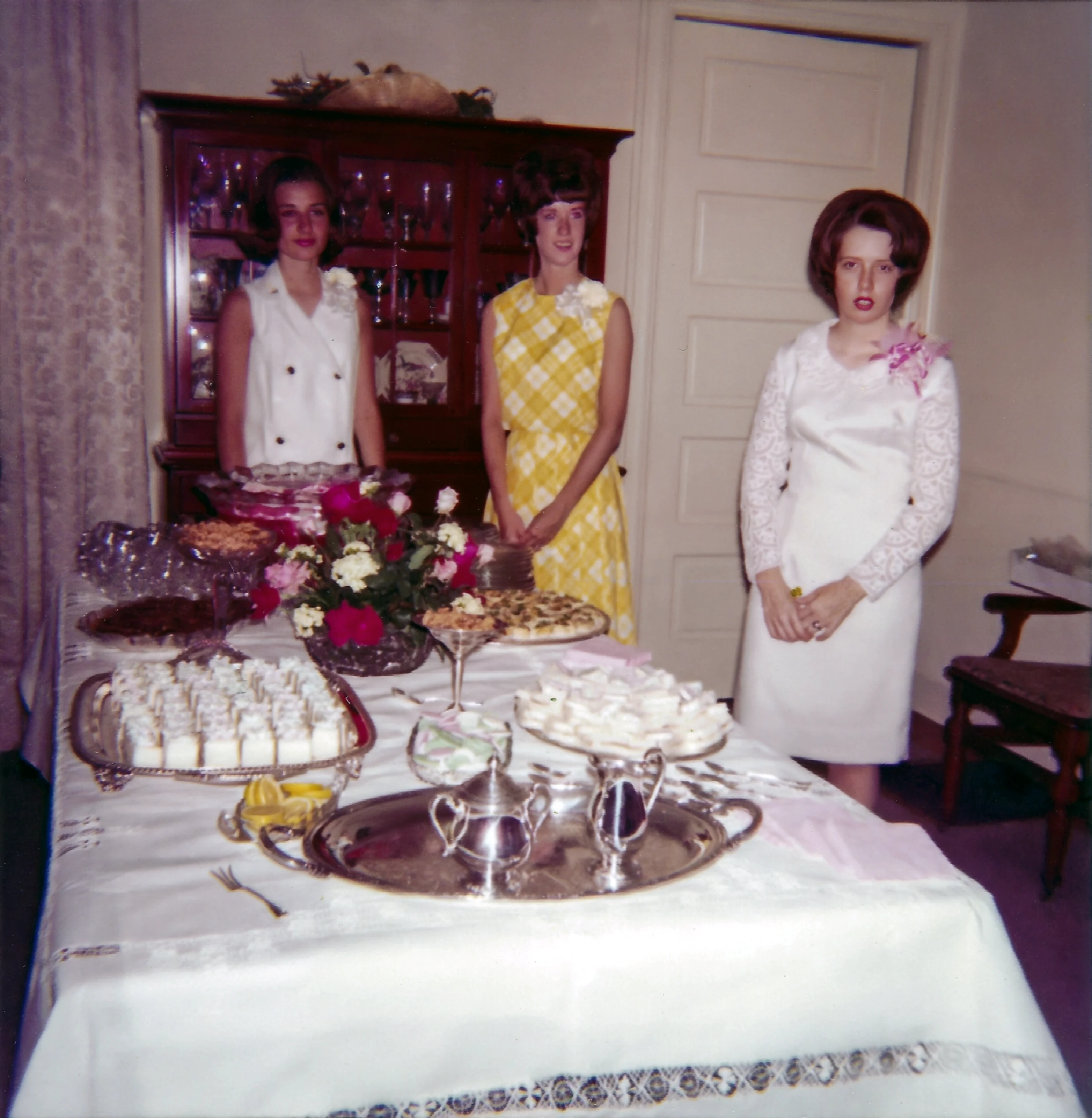 Cacky stands with friends beside a table of treats during her high school graduation party
