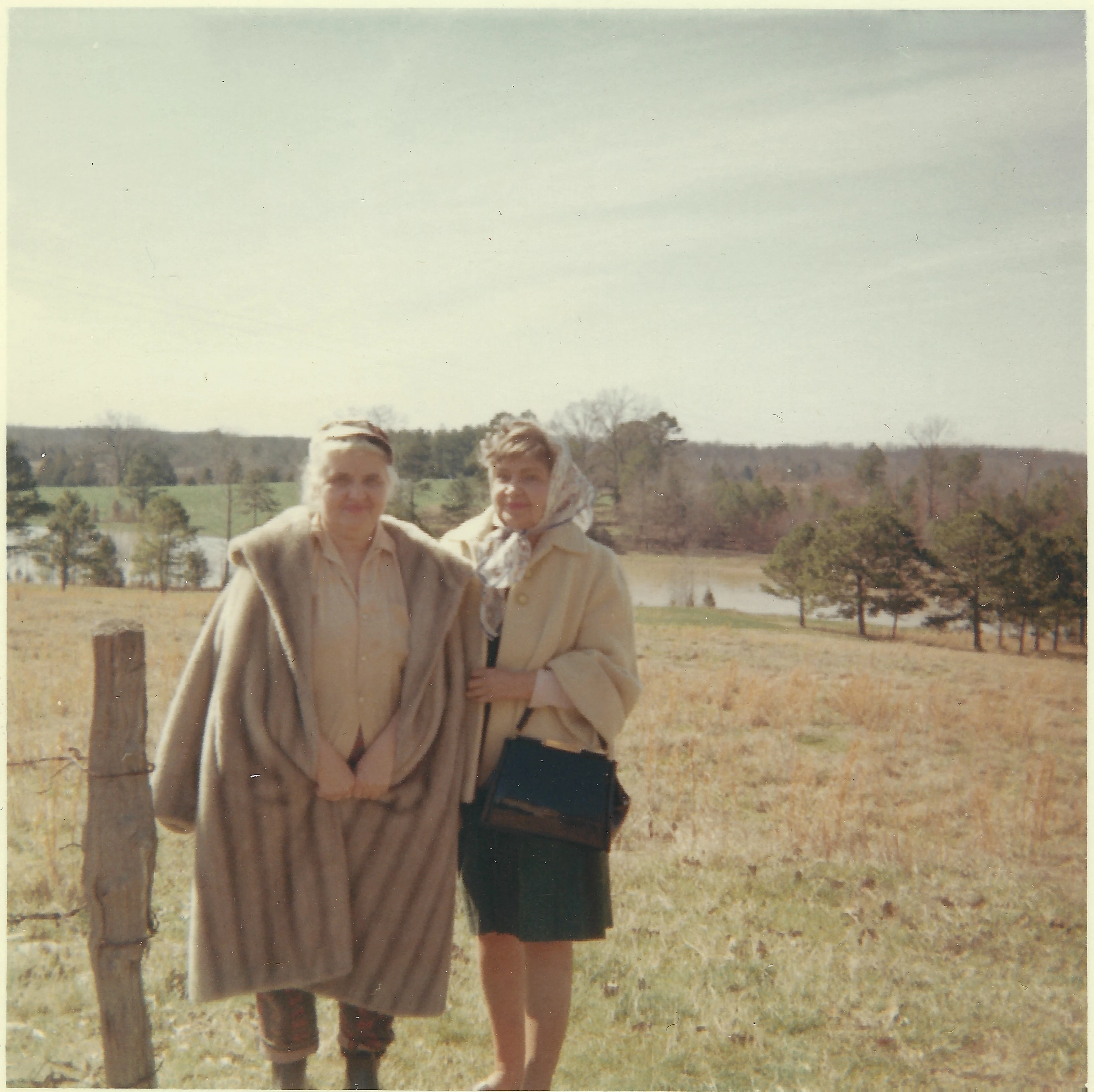 Mama Percy (Catherine Fleming) in a fur coat and another woman standing in a winter pasture by a pond; the print is lab-stamped July 1967