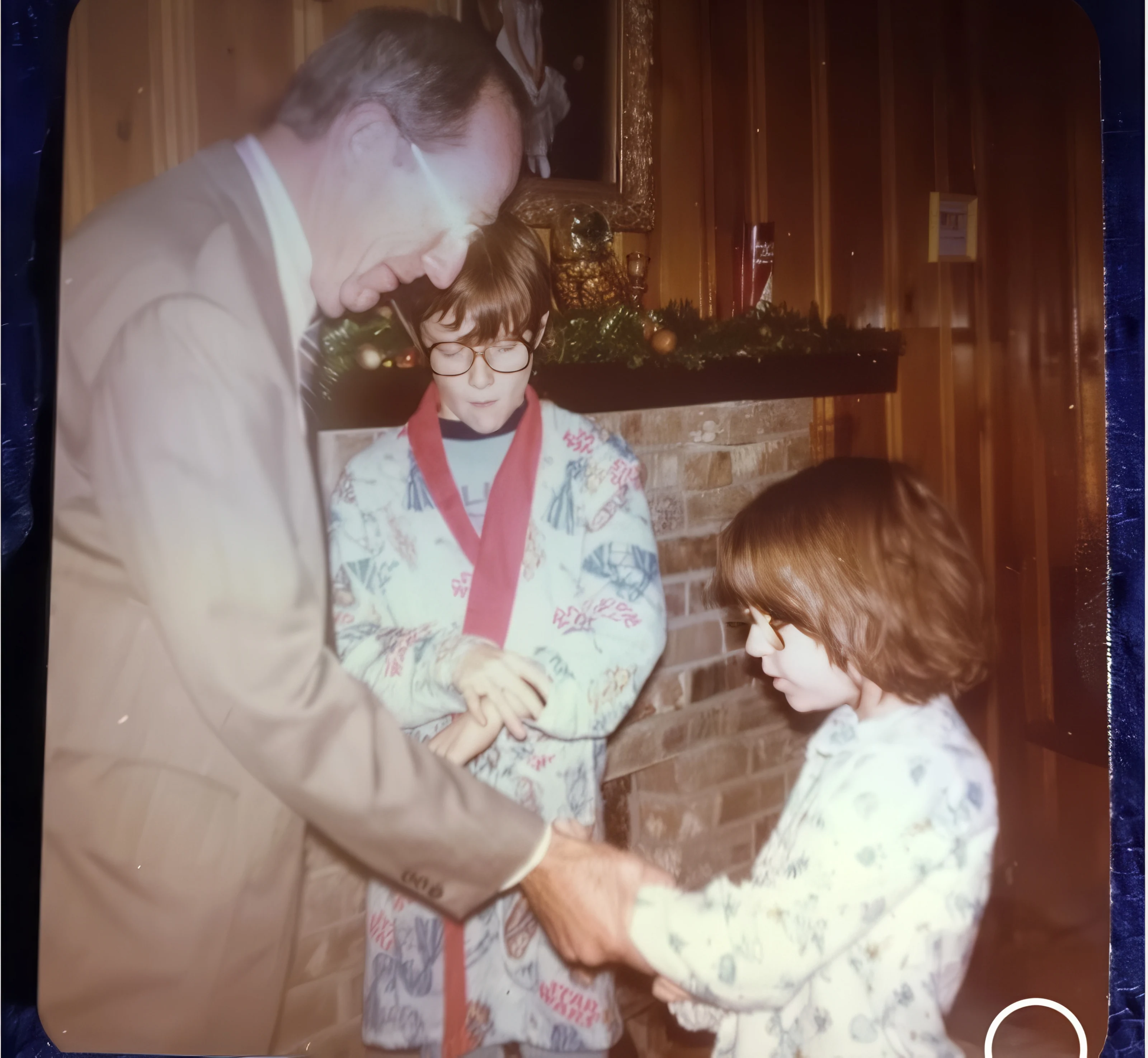 Big Goose with two grandchildren beside a decorated fireplace at Christmas.